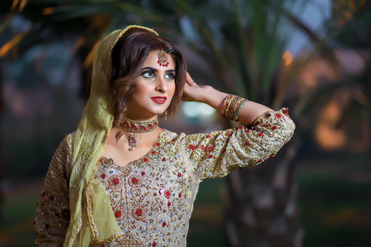 A woman elegantly dressed in traditional Pakistani attire with jewelry, showcasing cultural beauty.