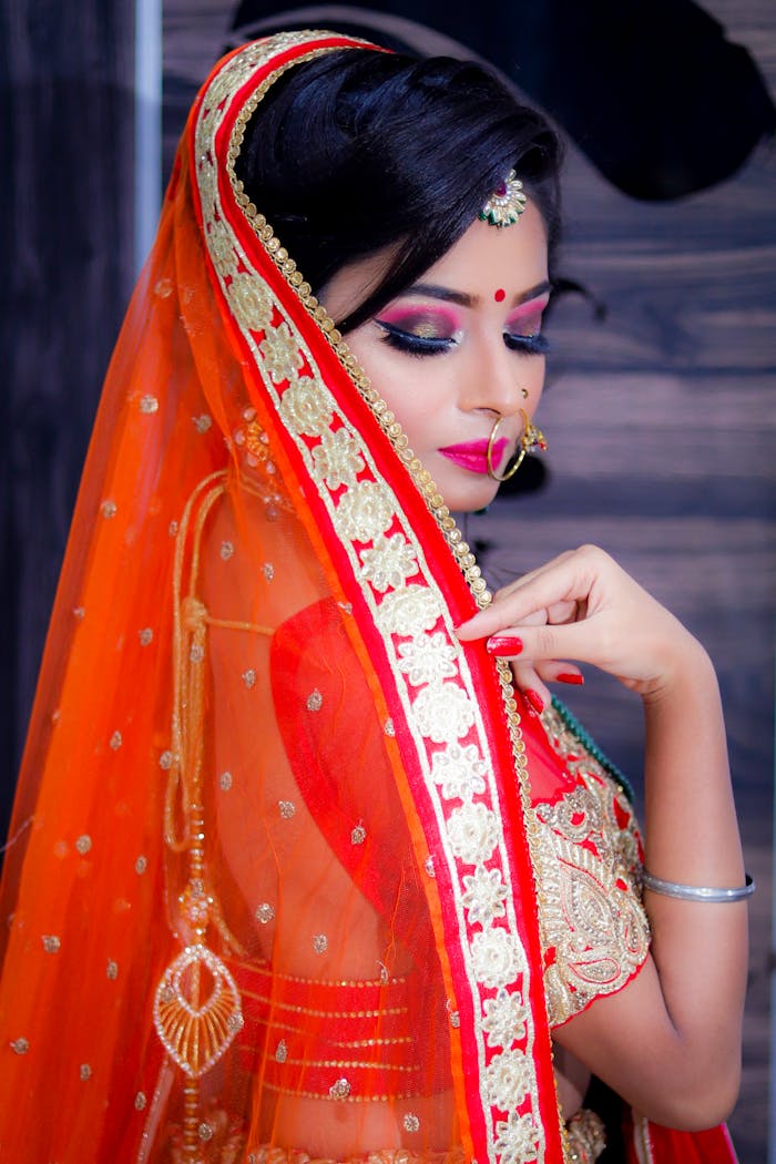 Vibrant portrait of woman in traditional Indian attire with exquisite jewelry and makeup.